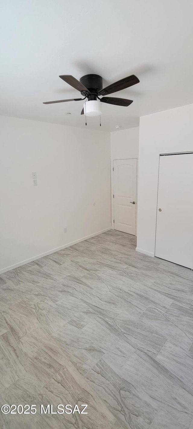 empty room with baseboards and a ceiling fan