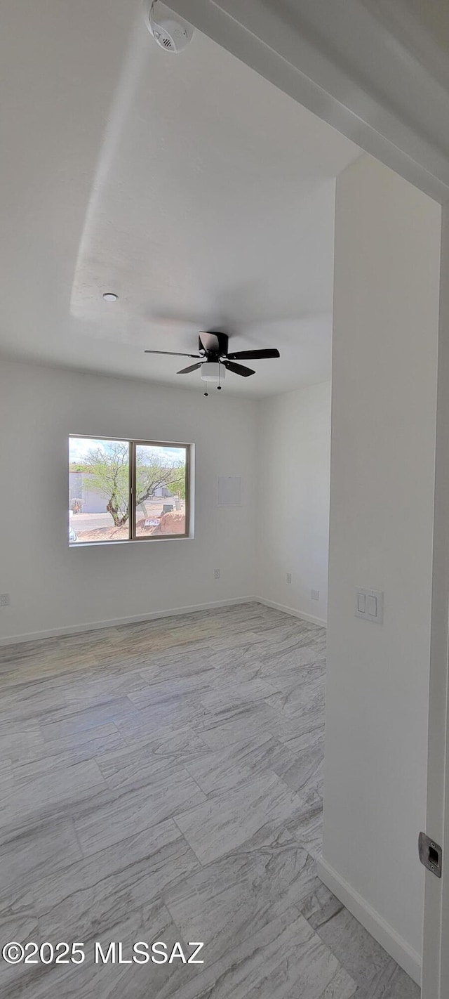 empty room with baseboards and a ceiling fan
