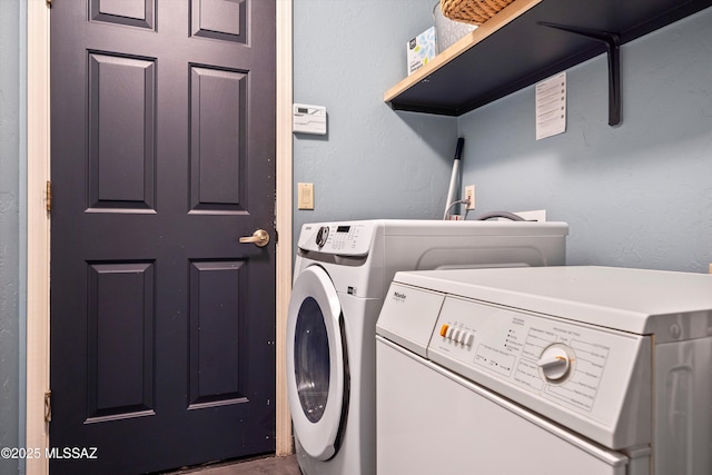clothes washing area featuring laundry area and washer and clothes dryer