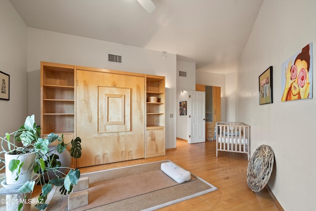workout room with baseboards, visible vents, and wood finished floors