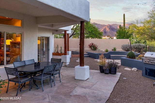 view of patio / terrace with fence, a mountain view, and outdoor dining space