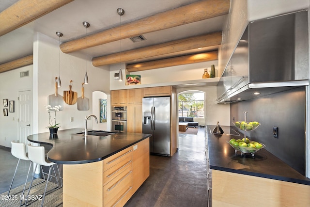 kitchen with dark countertops, beamed ceiling, finished concrete floors, a sink, and appliances with stainless steel finishes