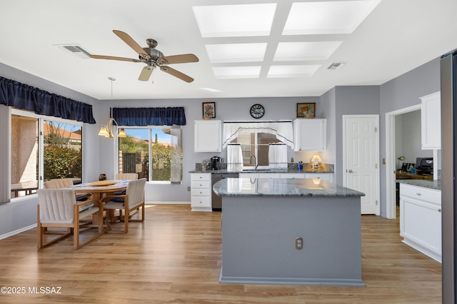 kitchen featuring light wood-style flooring, a sink, visible vents, ceiling fan, and dishwasher