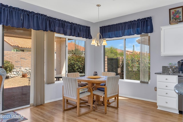 dining room with baseboards, light wood-type flooring, and a wealth of natural light