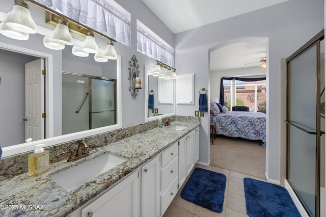 ensuite bathroom featuring a stall shower, a sink, tile patterned floors, and ensuite bathroom