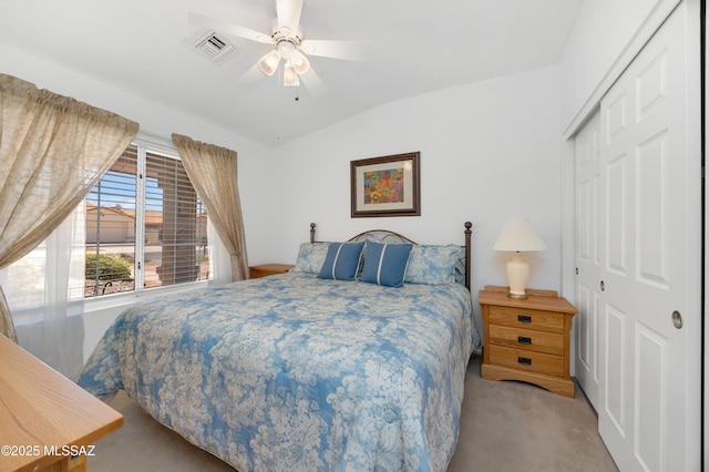 bedroom with a closet, a ceiling fan, visible vents, vaulted ceiling, and carpet floors