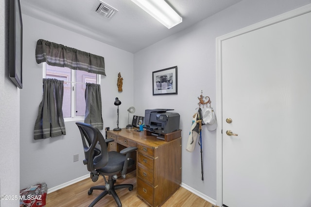 office area featuring baseboards, visible vents, and light wood finished floors