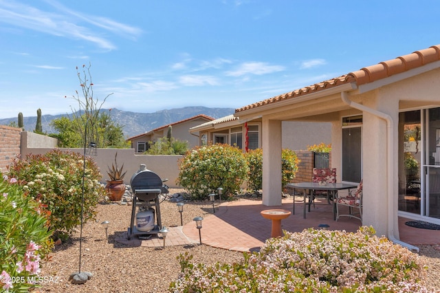 view of patio / terrace with outdoor dining space, area for grilling, a mountain view, and a fenced backyard