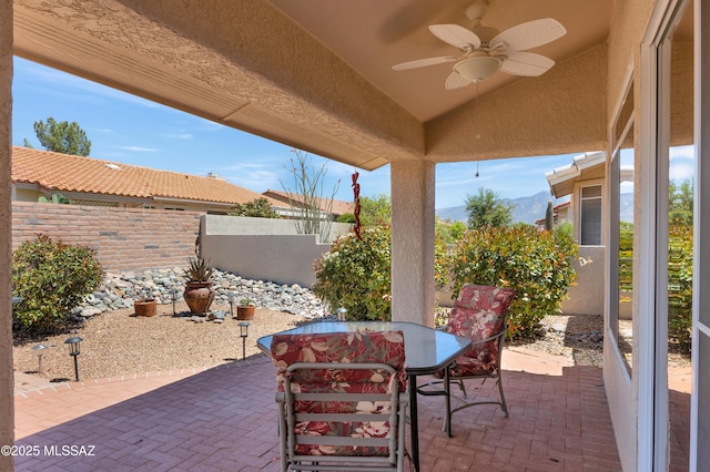 view of patio featuring outdoor dining area, ceiling fan, and fence private yard