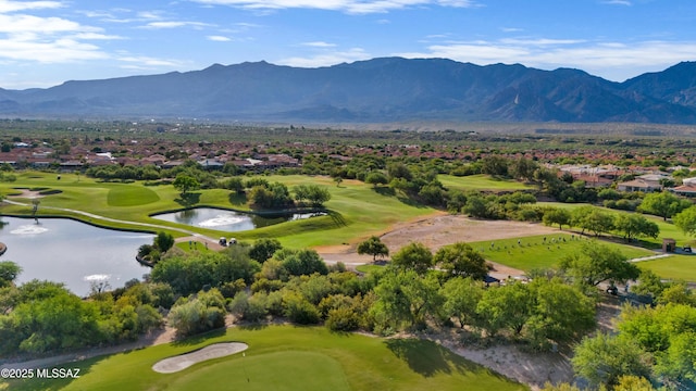 drone / aerial view featuring golf course view, a residential view, and a water and mountain view