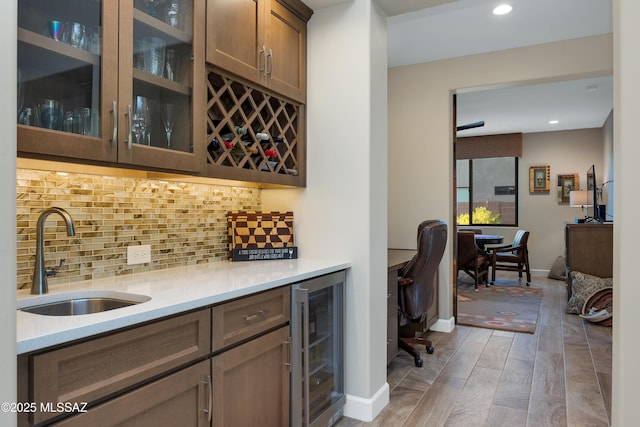 35605 S Overlook Dr, Saddlebrooke, AZ 85739 - bar featuring tasteful backsplash, beverage cooler, wood finished floors, a sink, and indoor bar
