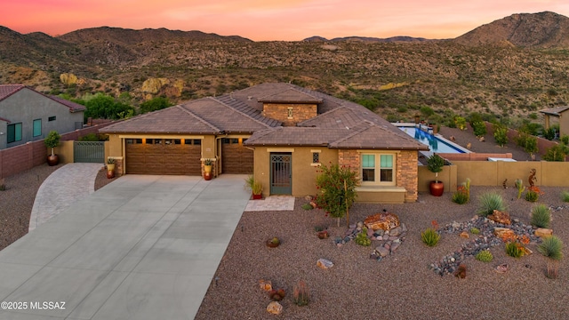 35605 S Overlook Dr, Saddlebrooke, AZ 85739 - prairie-style home featuring an attached garage, a mountain view, concrete driveway, stucco siding, and fence