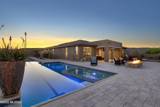 35605 S Overlook Dr, Saddlebrooke, AZ 85739 - pool at dusk with a patio, a fire pit, a fenced backyard, and a pool with connected hot tub