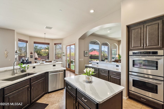 kitchen with appliances with stainless steel finishes, a sink, visible vents, and a healthy amount of sunlight
