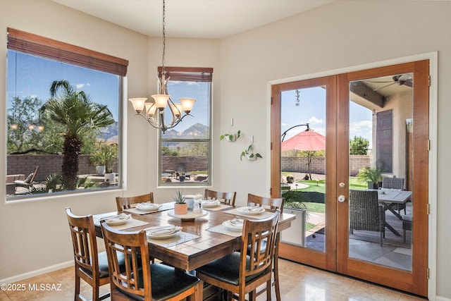 dining space with baseboards, french doors, a chandelier, and light tile patterned floors
