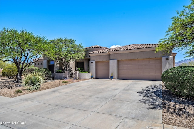 mediterranean / spanish-style home with stucco siding, concrete driveway, a tiled roof, and a garage