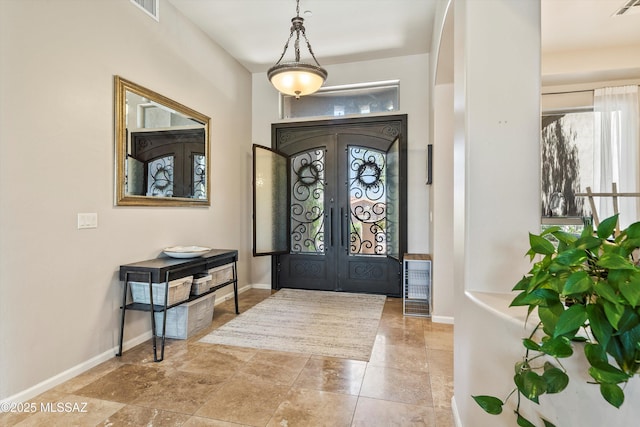 entryway featuring arched walkways, french doors, visible vents, and a wealth of natural light