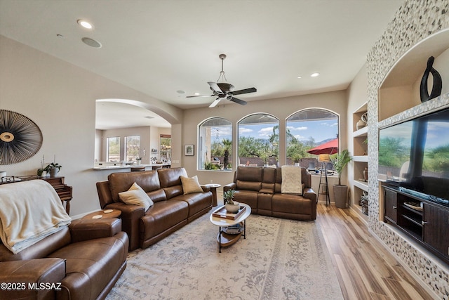 living room featuring ceiling fan, arched walkways, wood finished floors, and recessed lighting