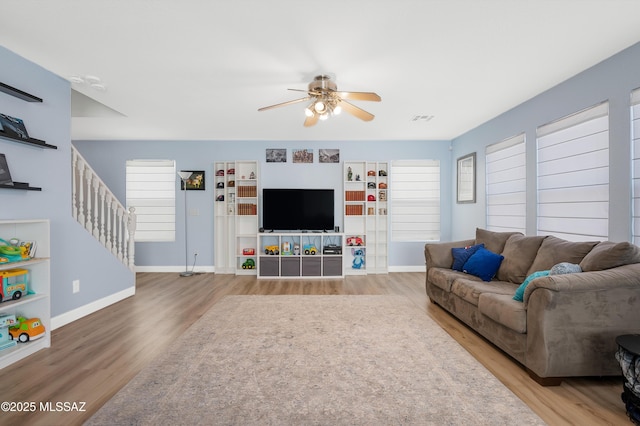 1985 S Mcconnell Dr, Tucson, AZ 85710 - living room with wood finished floors, ceiling fan, baseboards, and stairway