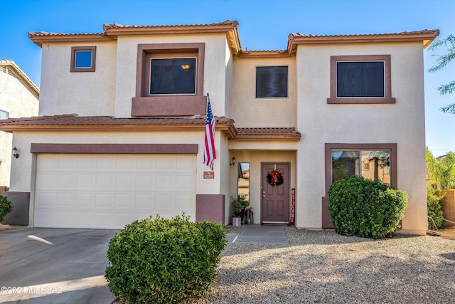 view of front of property with a garage, stucco siding, concrete driveway, and a tile roof