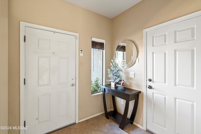 foyer entrance featuring light tile patterned floors and baseboards