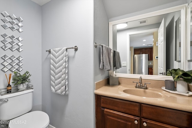bathroom with vanity, visible vents, and toilet