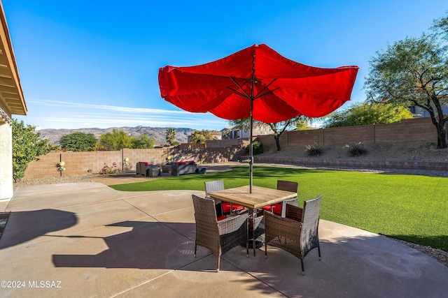 view of patio featuring a mountain view, outdoor dining space, and a fenced backyard