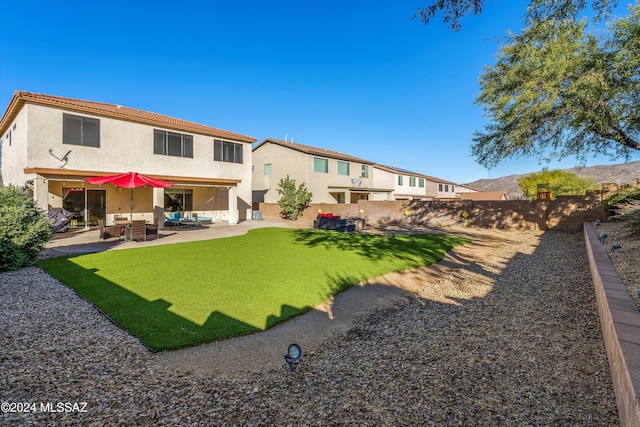 back of property with an outdoor hangout area, a fenced backyard, stucco siding, a lawn, and a patio area