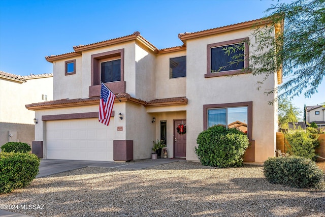 view of front of home featuring a garage, driveway, stucco siding, and a tile roof