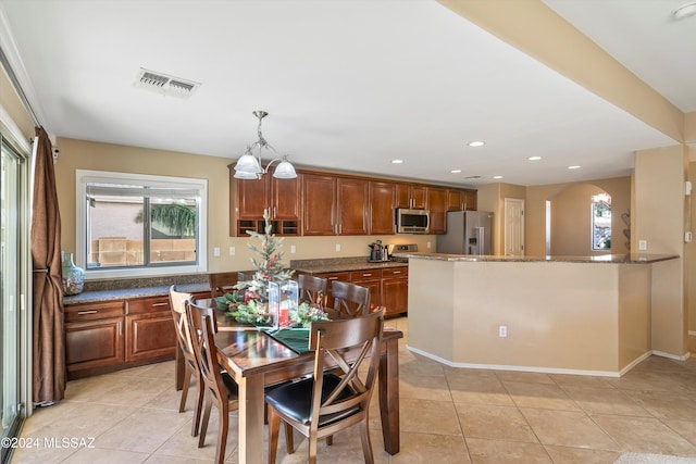 dining space featuring plenty of natural light, light tile patterned floors, and visible vents