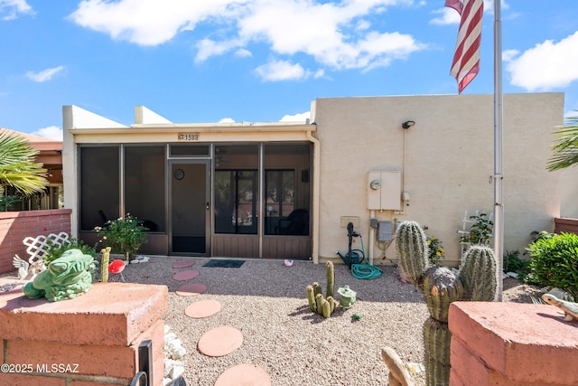 back of property featuring stucco siding and a sunroom