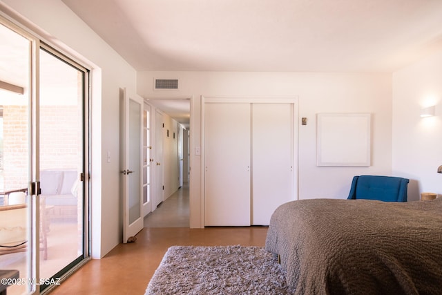 bedroom with access to outside, concrete floors, and visible vents