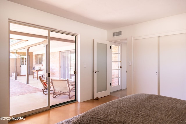 bedroom featuring wood finished floors, multiple windows, visible vents, and access to exterior