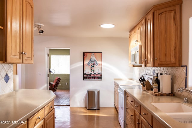 kitchen with decorative backsplash, a sink, white appliances, and light countertops