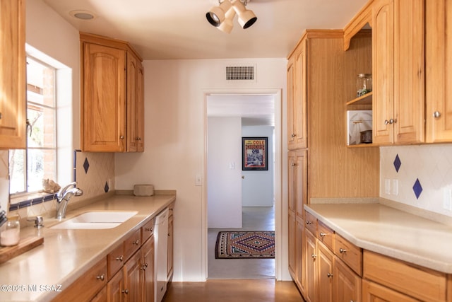 kitchen with light countertops, white dishwasher, decorative backsplash, and a sink