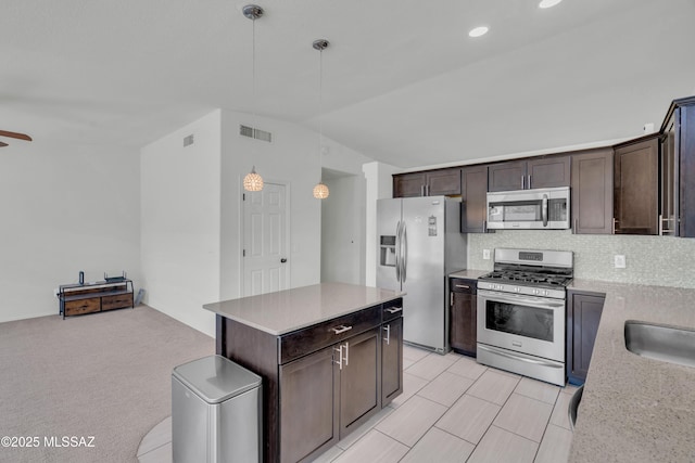 8972 E Mcmurray Pl, Tucson, AZ 85730 - kitchen with stainless steel appliances, dark brown cabinets, lofted ceiling, decorative light fixtures, and tasteful backsplash