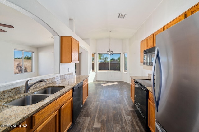 kitchen with brown cabinetry, visible vents, dark wood finished floors, a sink, and black appliances