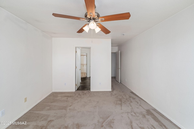unfurnished bedroom featuring carpet floors, ensuite bathroom, baseboards, and a ceiling fan