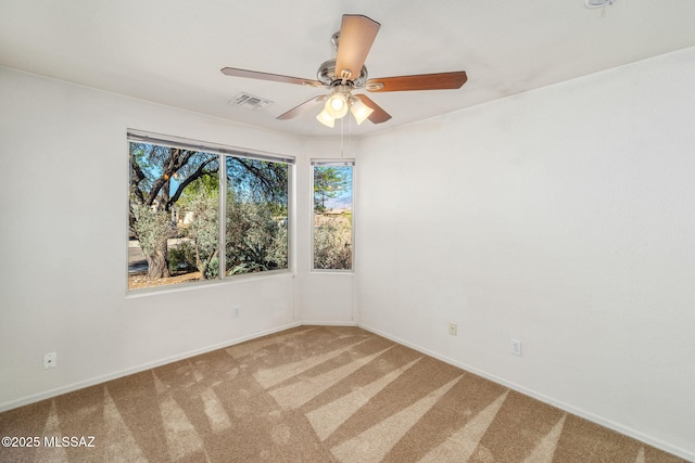 spare room with visible vents, a ceiling fan, carpet, and baseboards