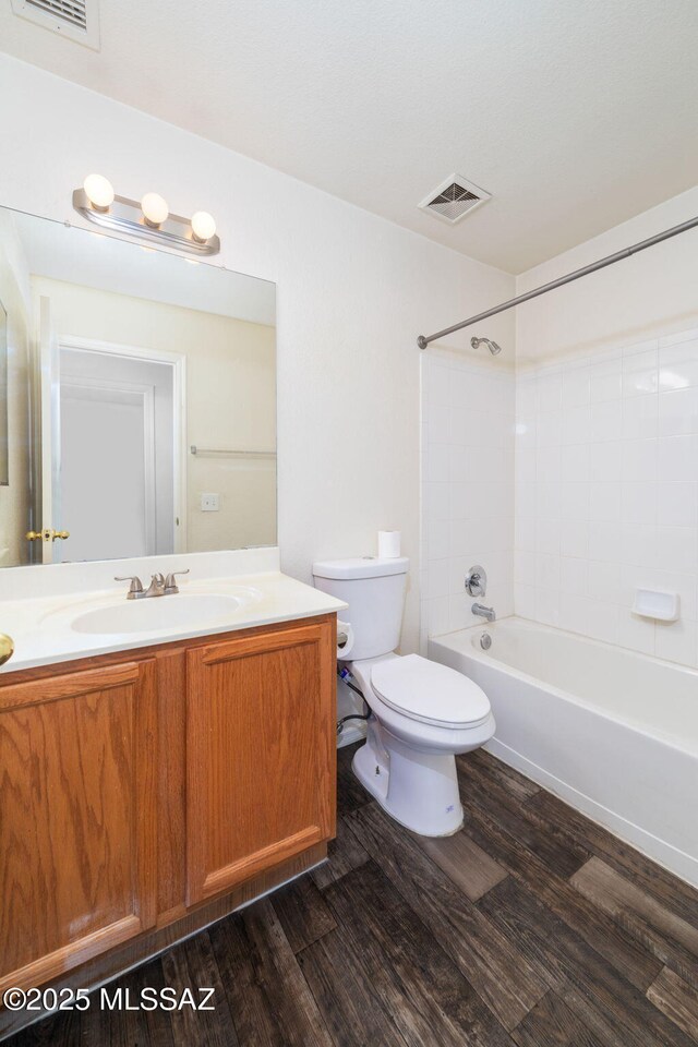 bathroom with visible vents, wood finished floors, toilet, and vanity