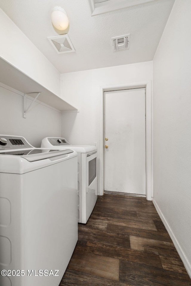 laundry room featuring visible vents, laundry area, dark wood-style flooring, and washer and dryer