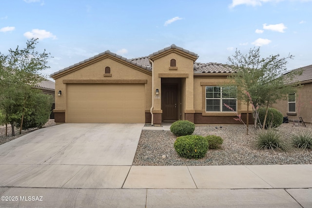 mediterranean / spanish-style home with a tiled roof, an attached garage, driveway, and stucco siding