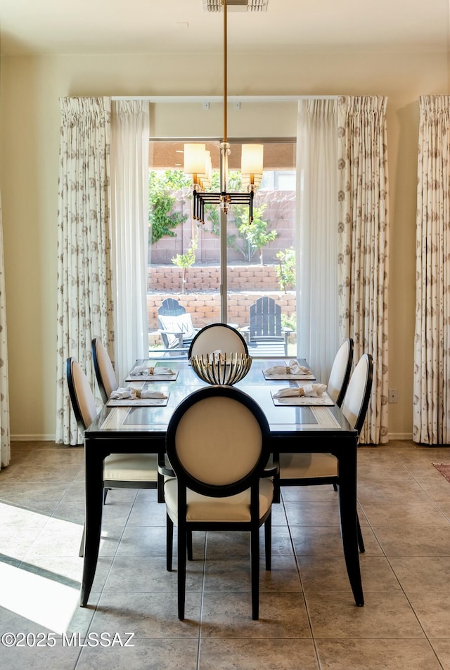 dining room with a healthy amount of sunlight, a notable chandelier, and baseboards