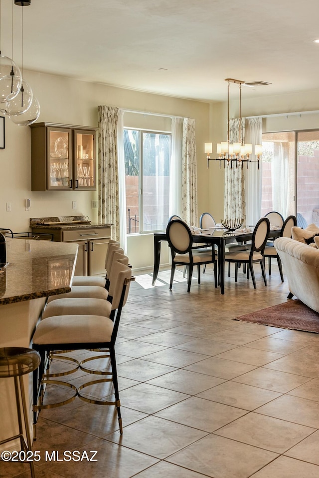 dining area with light tile patterned floors and a notable chandelier