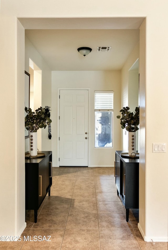 foyer entrance with visible vents, baseboards, and tile patterned flooring