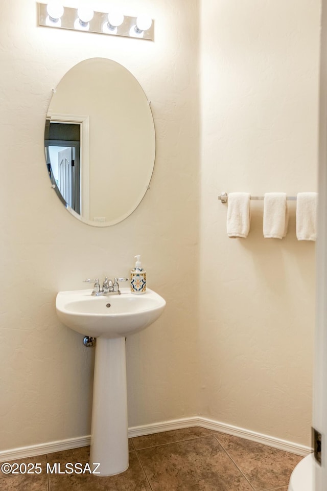 bathroom with a sink, tile patterned flooring, and baseboards