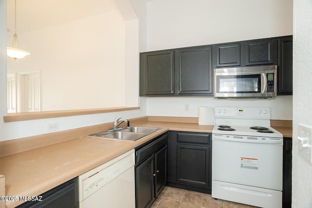 kitchen featuring white appliances, arched walkways, light countertops, a sink, and decorative light fixtures