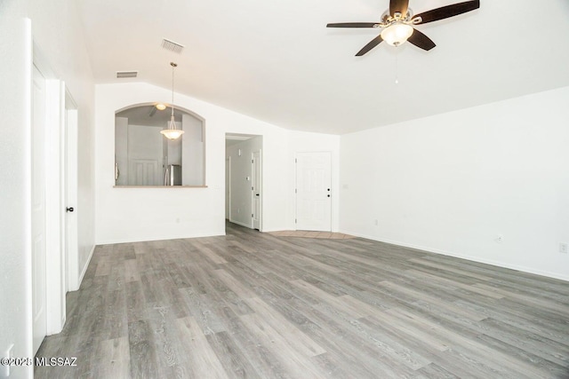 unfurnished living room with vaulted ceiling, a ceiling fan, wood finished floors, and visible vents