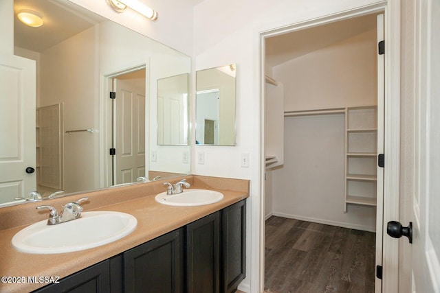 full bath featuring wood finished floors, a sink, and double vanity