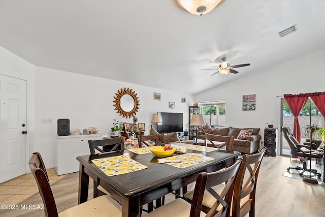 dining room featuring light wood-type flooring, vaulted ceiling, visible vents, and ceiling fan